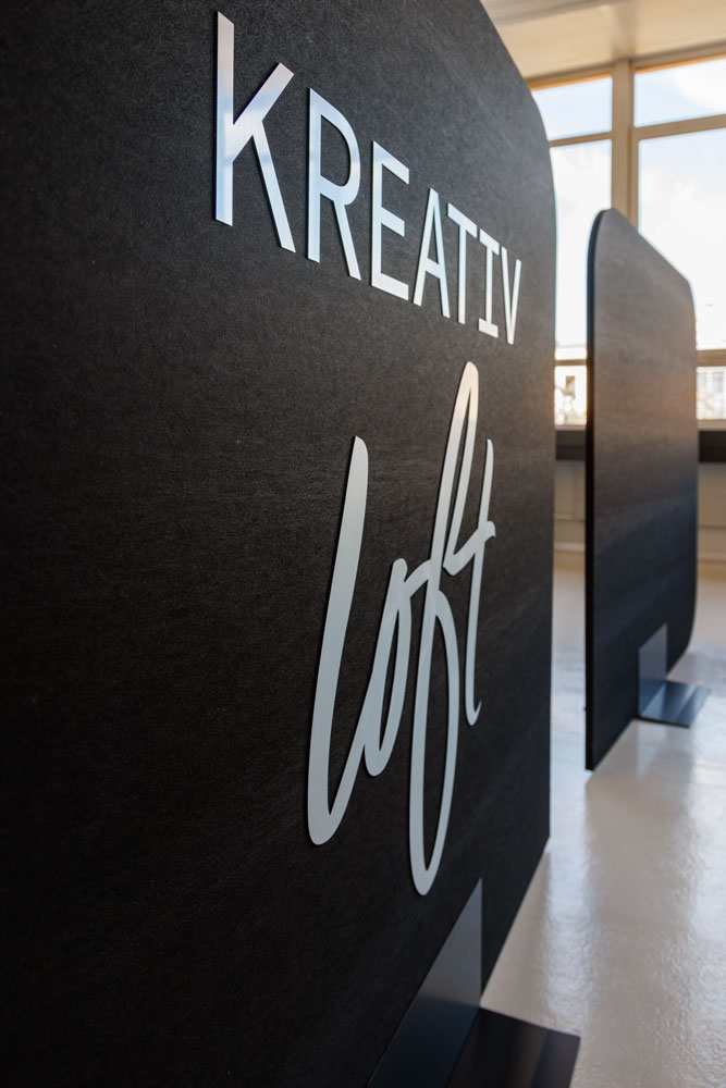 Schwarze Akustikwand mit dem kreativloft-Logo im Loft in Solothurn